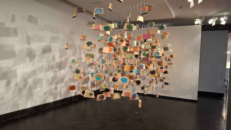 A hanging installation of painted wood pieces at the Museum of Fine Arts